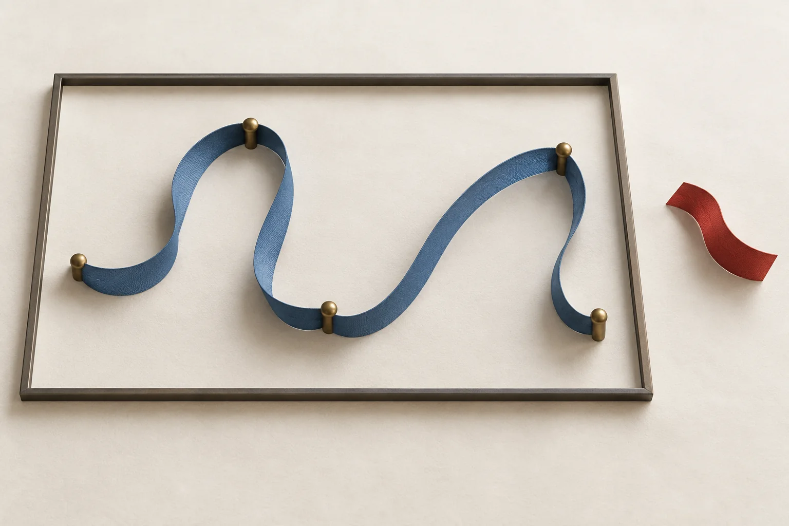 A fixed rectangular frame containing a loose ribbon arranged along several possible paths, with small pinned anchors.